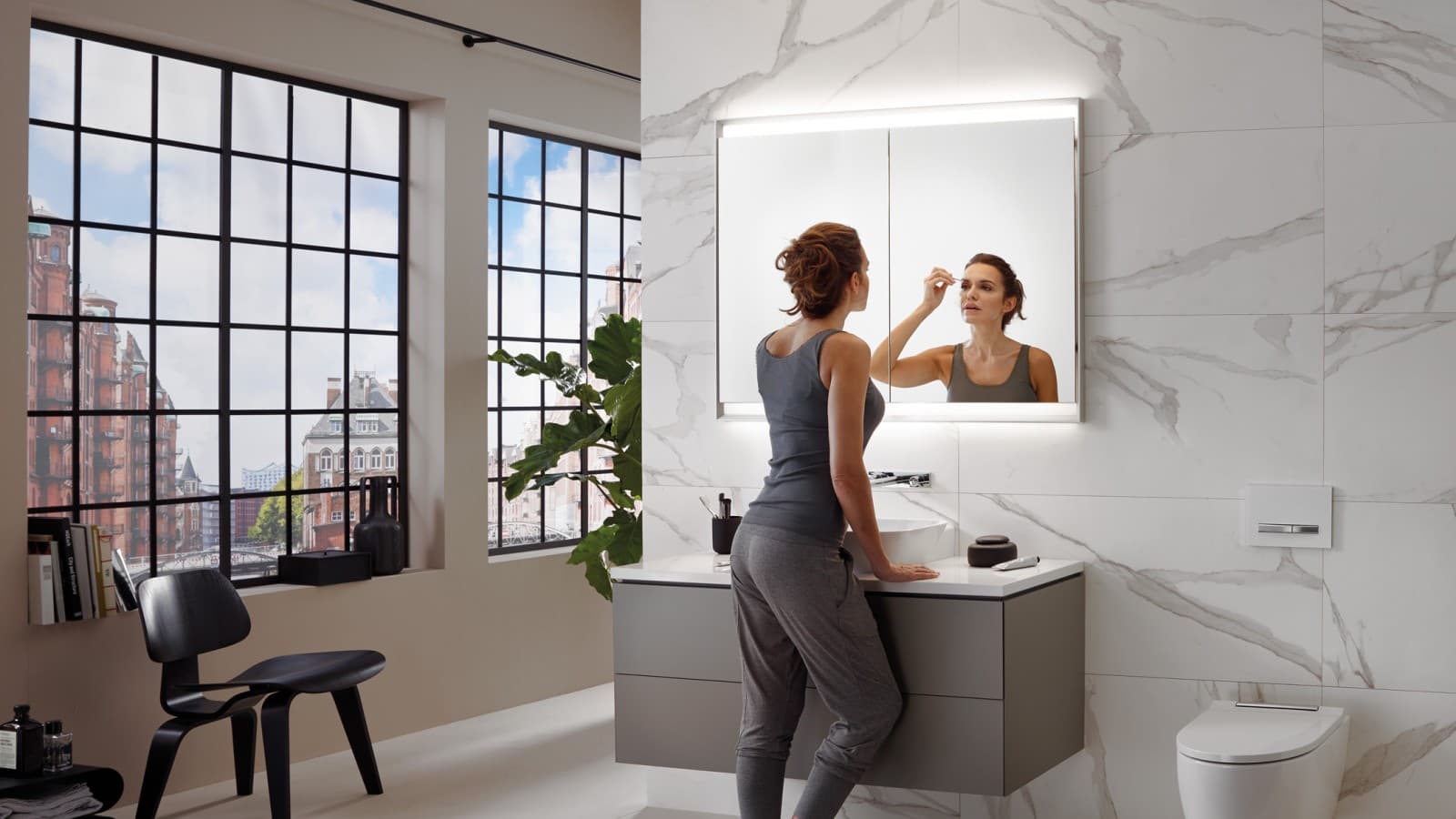 Kvinna i ett badrum med Geberit ComfortLight Kvinna i ett badrum med Geberit ComfortLight