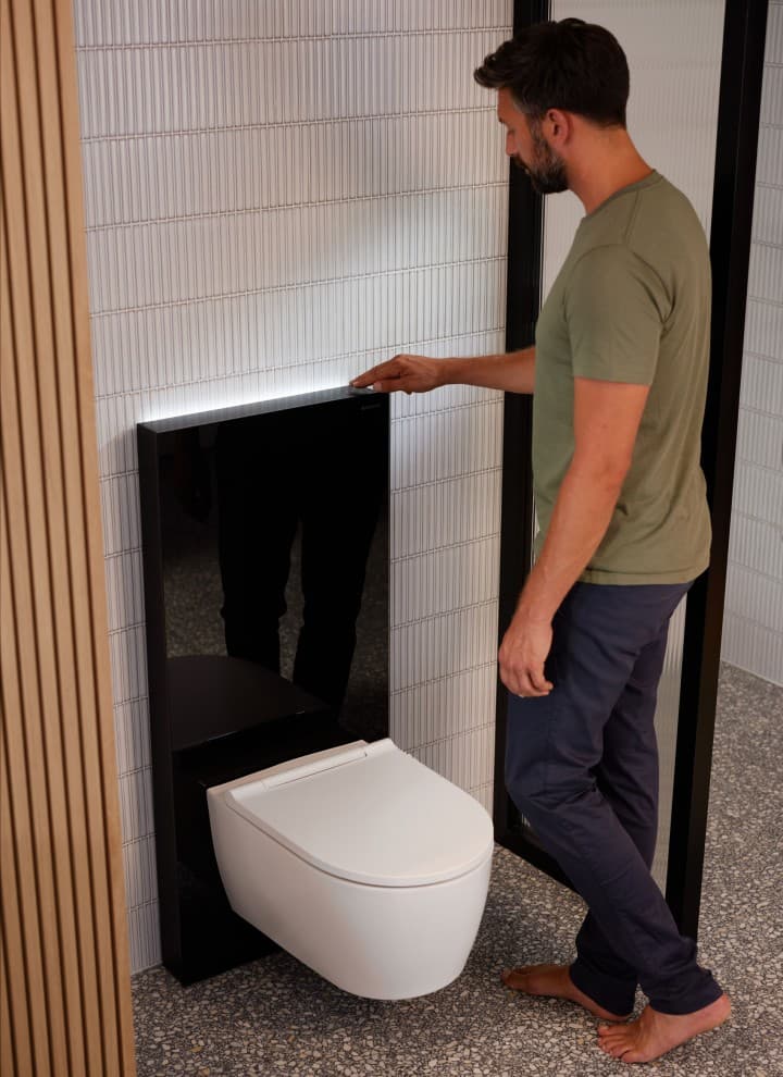 Man bredvid Geberit Monolith Plus med ComfortLight Man bredvid Geberit Monolith Plus med ComfortLight