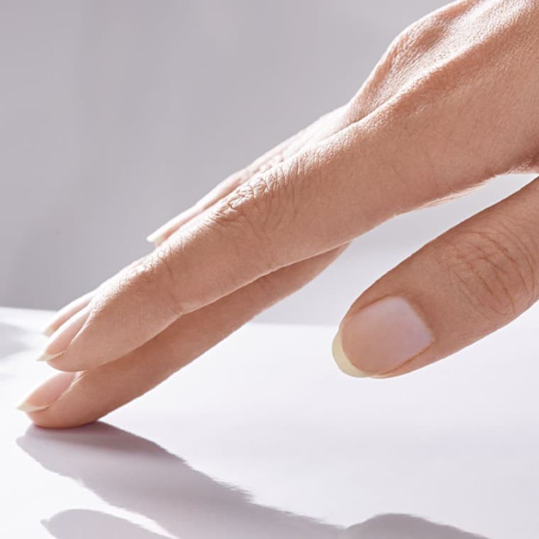 Hand som stryker över en porslinsyta Hand som stryker över en porslinsyta